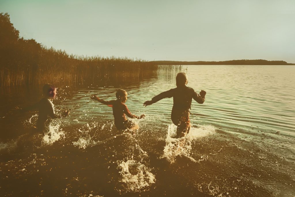 Lapset juoksevat mereen Mathildedalin hiekkarannalla