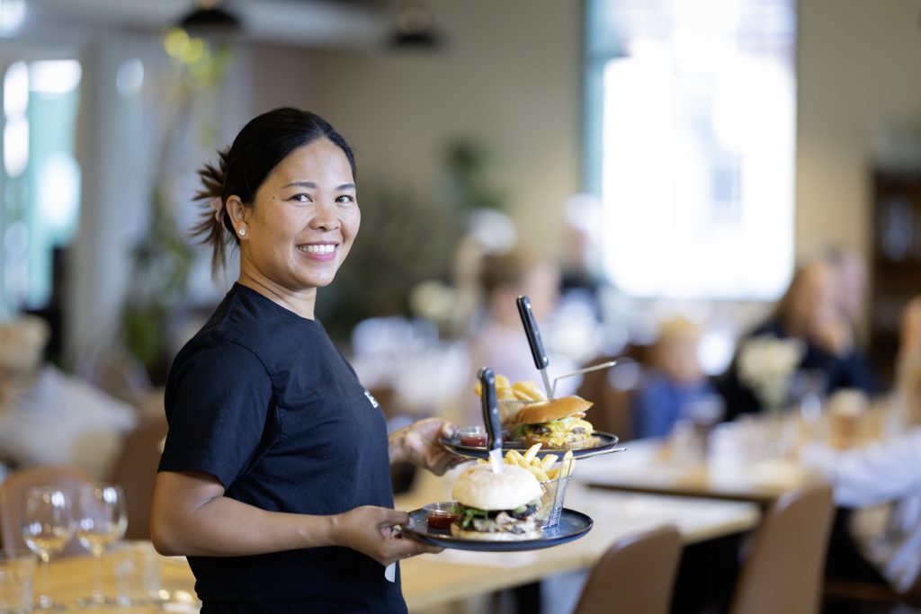 Julie Maaniemi vkäsissään kaksi burgeri annosta