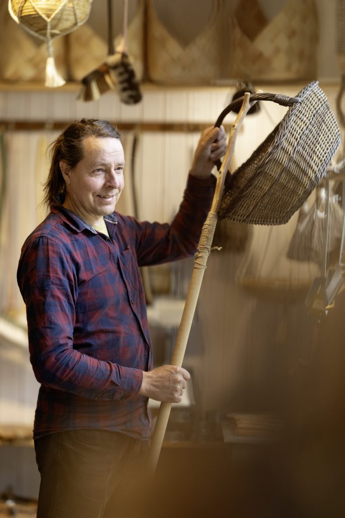 Kai Heiskanen laskemassa koria alas puotinsa hyllyltä.